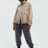 Model wearing The Crown Carmel Statement Jacket with sweatpants and combat boots