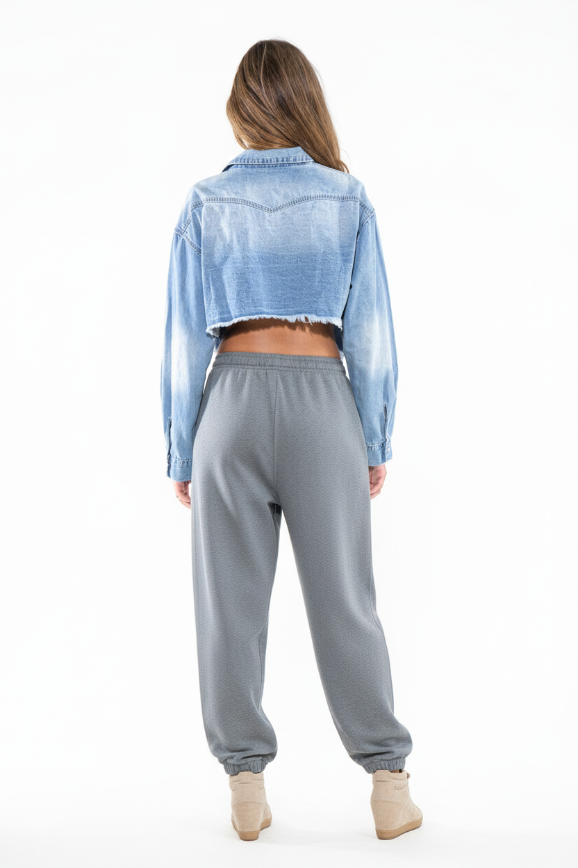 The Frayed Edge Cropped Denim Shirt back view showing cropped silhouette with grey baggy sweatpants and Isabel Marant sneakers