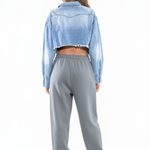 The Frayed Edge Cropped Denim Shirt back view showing cropped silhouette with grey baggy sweatpants and Isabel Marant sneakers